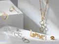 Złota biżuteria w kształcie serc i napisu "LOVE". Cechy złota: blask, trwałość i symbolika miłości.