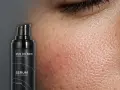 Czy serum z wit C można stosować latem? Zbliżenie na skórę i buteleczkę serum z witaminą C, E i kwasem ferulowym.