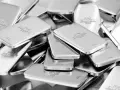 Stos drobnych sztabek "FINE SILVER 999.9" o wadze 1000g, ukazujący gęstość srebra.