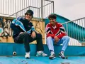 Dwóch uśmiechniętych chłopaków w kurtkach w stylu lat 80. Polska moda sportowa w najlepszym wydaniu.