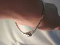 Srebrna bransoletka Pandora na nadgarstku. Pozwala to ocenić rozmiary bransoletek Pandora i dopasowanie.