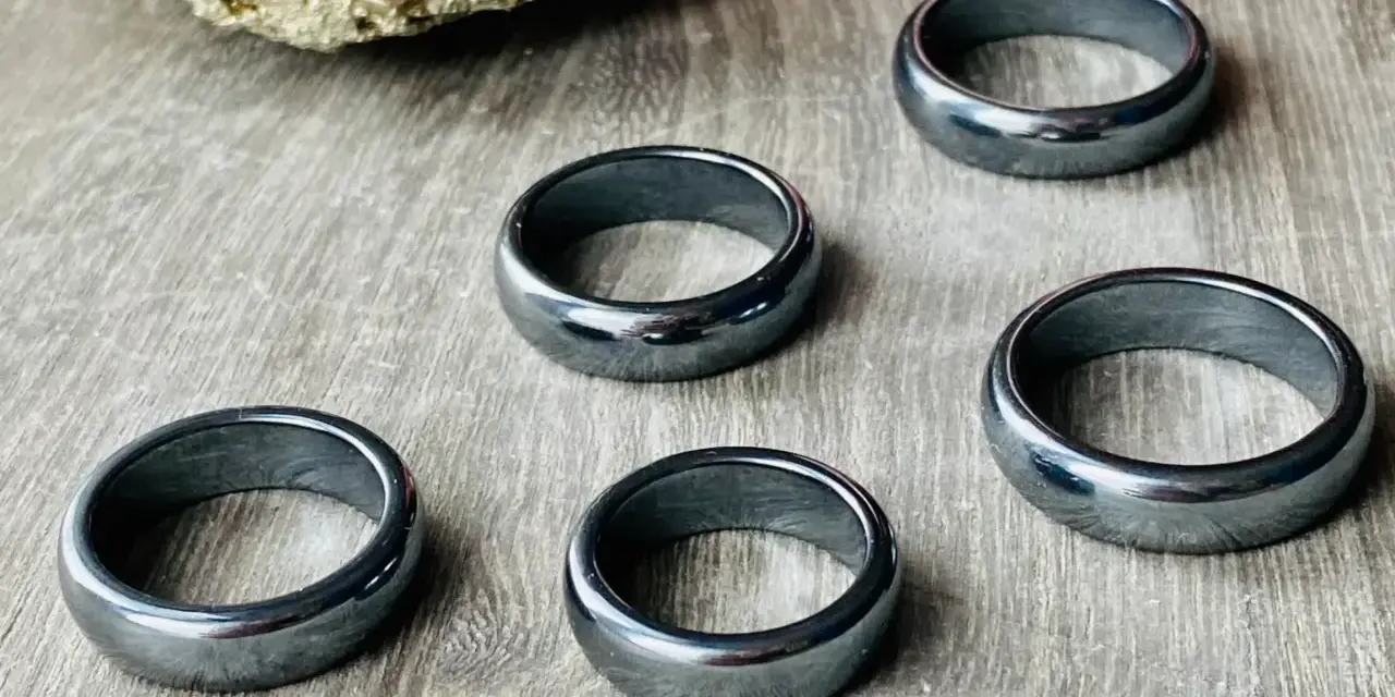 Pięć błyszczących, ciemnoszarych pierścionków. Jak rozpoznać hematyt? Ten kamień ma charakterystyczny metaliczny połysk i jest ciężki.