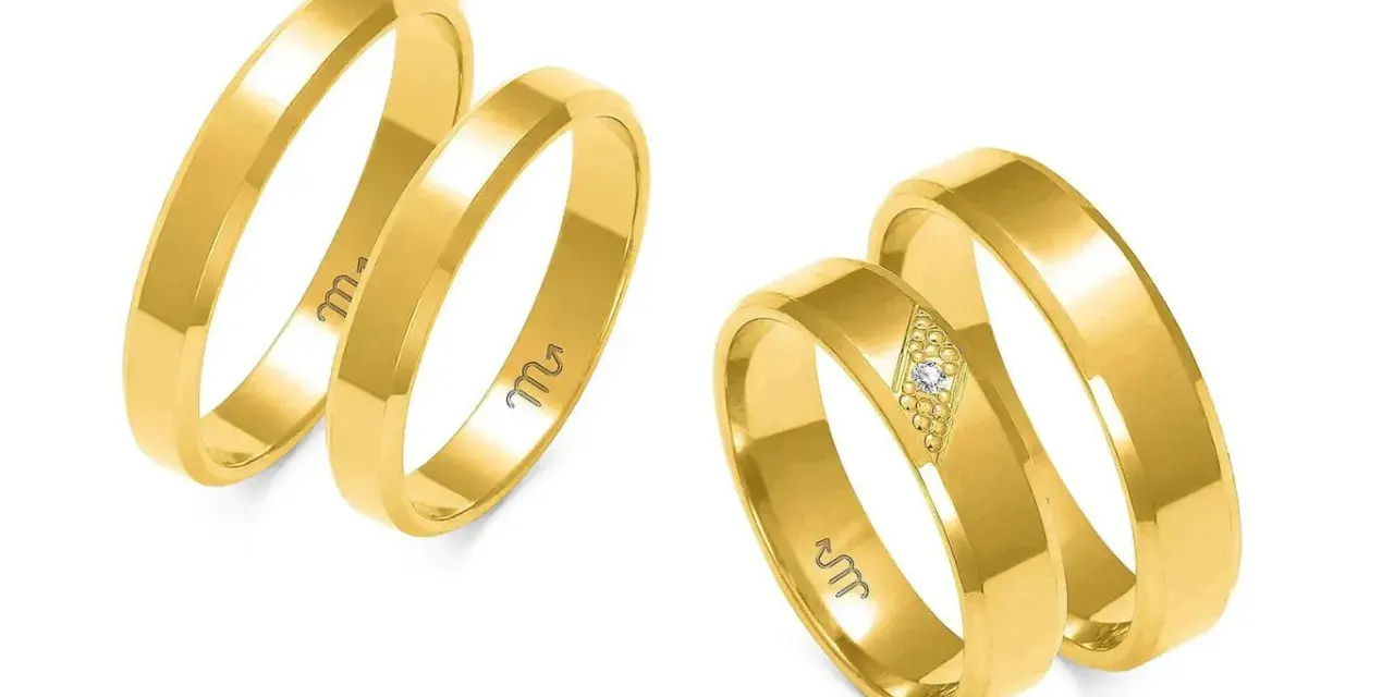 Złote obrączki fazowane, jedna z brylantem, symbolizują trwałość związku.