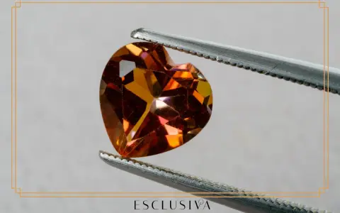 Sercowaty topaz, kamień szlachetny, idealny dla znaku zodiaku Skorpion, błyszczy w pęsecie.