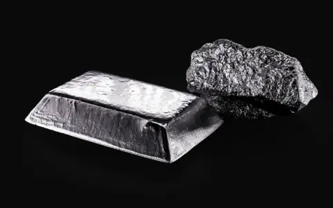 Sztabka i bryła platyny, najdroższego metalu szlachetnego, na czarnym tle.