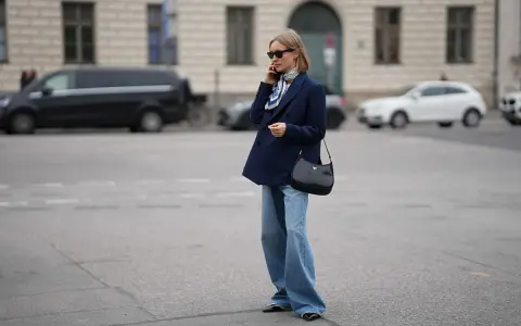 Eleganckie jeansy i granatowa marynarka damska tworzą stylową, miejską stylizację.
