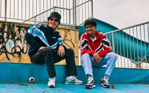 Dwóch uśmiechniętych chłopaków w kurtkach w stylu lat 80. Polska moda sportowa w najlepszym wydaniu.