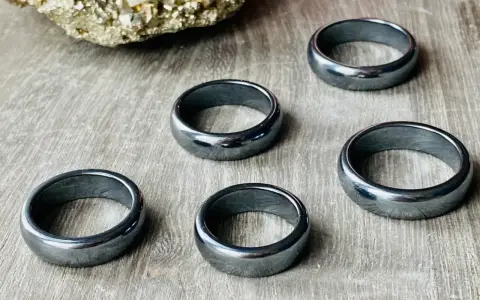 Pięć błyszczących, ciemnoszarych pierścionków. Jak rozpoznać hematyt? Ten kamień ma charakterystyczny metaliczny połysk i jest ciężki.