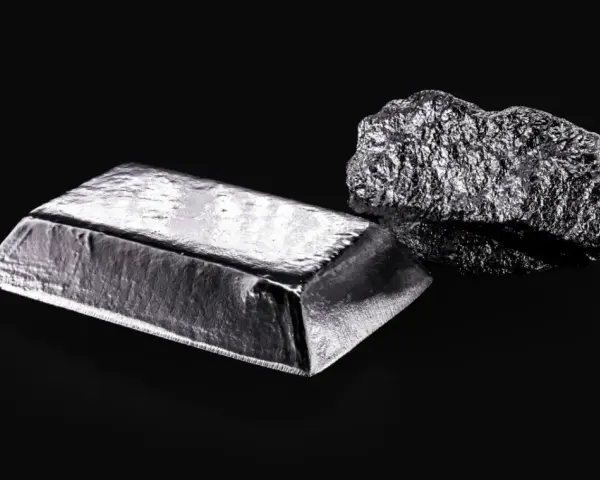 Sztabka i bryła platyny, najdroższego metalu szlachetnego, na czarnym tle.