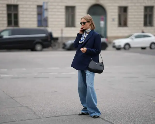 Eleganckie jeansy i granatowa marynarka damska tworzą stylową, miejską stylizację.