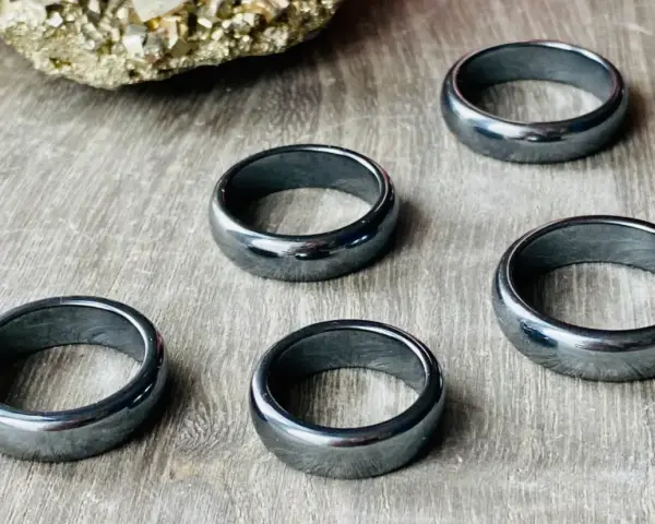 Pięć błyszczących, ciemnoszarych pierścionków. Jak rozpoznać hematyt? Ten kamień ma charakterystyczny metaliczny połysk i jest ciężki.