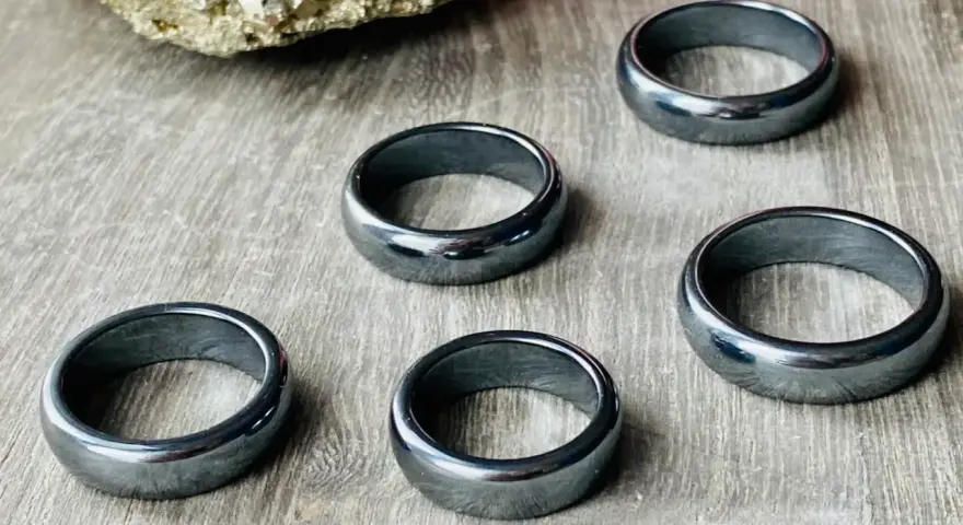 Pięć błyszczących, ciemnoszarych pierścionków. Jak rozpoznać hematyt? Ten kamień ma charakterystyczny metaliczny połysk i jest ciężki.