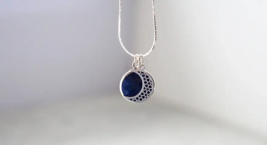 Srebrny naszyjnik z lapis lazuli w kształcie księżyca. Dowiedz się, jak wyczyścić srebrną biżuterię z kamieniami, by lśniła jak gwiazdy.