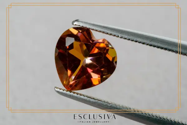 Sercowaty topaz, kamień szlachetny, idealny dla znaku zodiaku Skorpion, błyszczy w pęsecie.